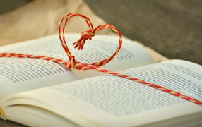 Сердце из веревки лежит на открытой книге