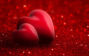 Two red hearts on a brilliant red background