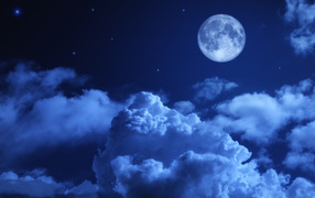 A big moon in the night sky with white clouds