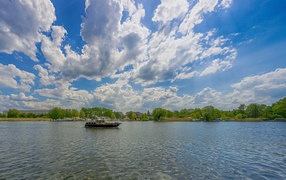Boat on the lake under a beautiful blue sky with white clouds