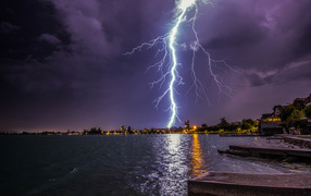 Bright lightning in the sky against the background of water
