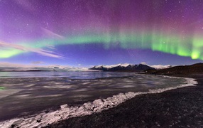 Northern lights in the sky over a lake covered with ice