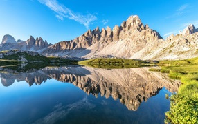 The mountains and the blue sky are reflected in clear water