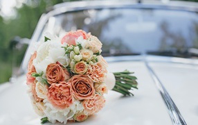 A wedding bouquet of roses lies on the car