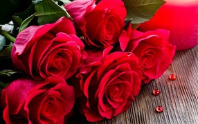 Красивый букет роз лежит на деревянной поверхности