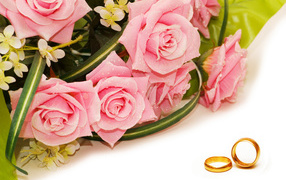 Bouquet of pink roses with gold wedding rings