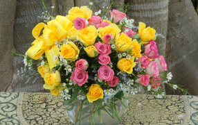Bouquet of yellow and pink roses in a glass vase