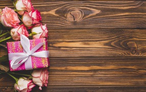 Подарочная коробка с букетом роз на деревянном фоне 