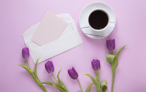 Сиреневые тюльпаны с письмом и чашкой кофе на столе 