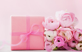 Розовый подарок с букетом розовых лютиков на розовом фоне