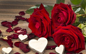 Three large red roses with wooden hearts