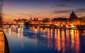 Jetty near the river in the light of the night lights of the city of Paris, France