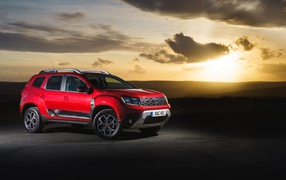 Red SUV Dacia Duster Techroad 2019 year against the sky at sunset