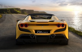 Желтый спортивный автомобиль Ferrari F8 Spider 2019 года на дороге у моря