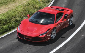 Красный автомобиль Ferrari F8 Tributo 2019 года на дороге
