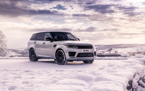 Silver Range Rover Sport SUV stands in the snow
