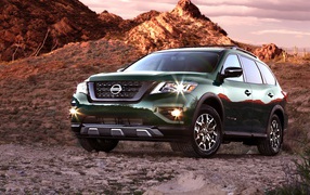 Green car Nissan Pathfinder in the mountains