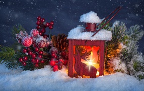 Рождественский фонарь на снегу с еловой веткой