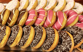 Lots of delicious sweet donuts with icing on the table