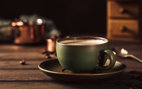 Большая чашка кофе на столе с кофейными зернами 