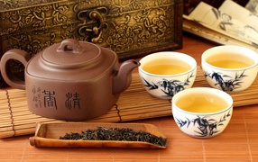 Китайский чайник на столе с чашками