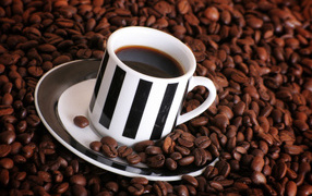Чашка кофе на столе с кофейными зернами