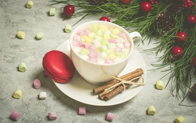 Drink with marshmallows on a saucer with macaroon and cinnamon