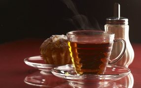 Fragrant cup of hot tea on the table with a cupcake