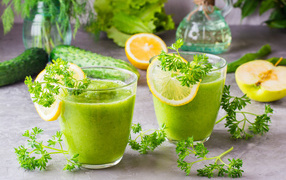 Зеленый смузи в стаканах с кусочками лимона и петрушкой
