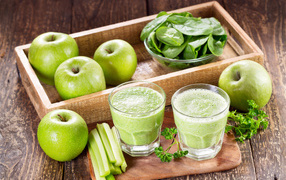 Смузи на столе с зелеными яблоками и зеленью 