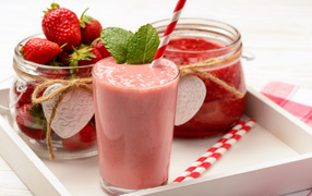 Strawberry smoothie on a tray with berries and jam