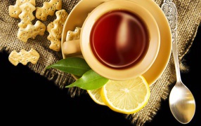 Чай на столе с печеньем и кусочками лимона
