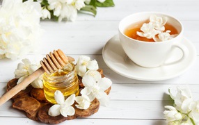 Чай на столе с медом и цветами жасмина