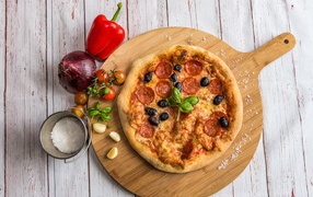 Пицца на доске с овощами и солью 