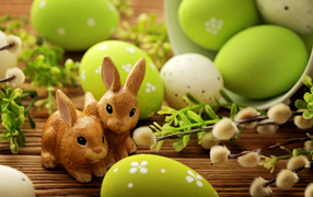 Крашеные яйца с веткой вербы и фигурками кроликов на праздник Пасха