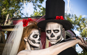 Пара жених и невеста с масками с грима на лице на Хэллоуин 