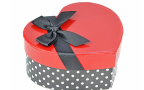 Beautiful heart shaped box with black bow on white background