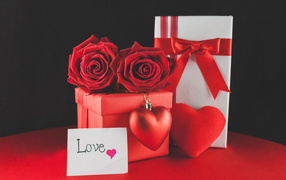 Gift boxes on the table with red roses and heart
