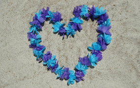Heart of flowers on the sand on the beach