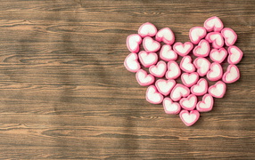 Сердце из конфет на деревянном столе