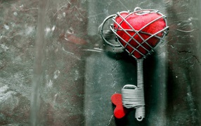 Ключ с красным сердцем на сером столе