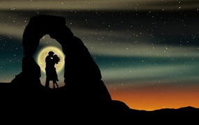 Kiss of a couple in love in the mountains against the background of the moon