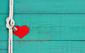 Red heart on a rope with a lock on a blue background