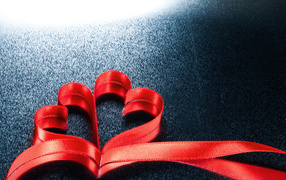 Two red hearts from a ribbon on a gray background
