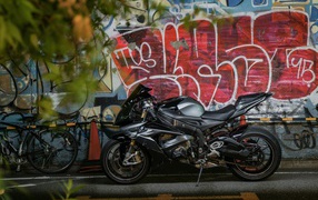 Black motorcycle BMW S1000RR on the background of a painted wall