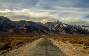 Long deserted road goes to the mountains