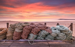 Ropes on a wooden bridge on a sunset background