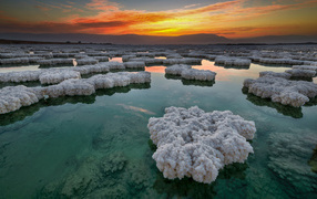 Salt deposits in the water under a beautiful sky at sunset