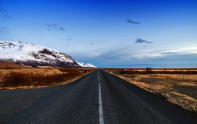 Smooth asphalt road near the snowy mountains