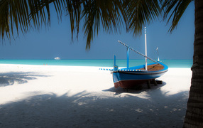 Boat on the white sand by the ocean in the tropics